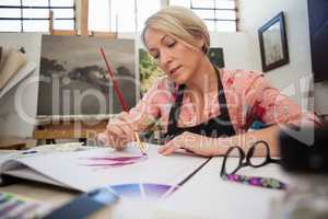 Woman painting in drawing book