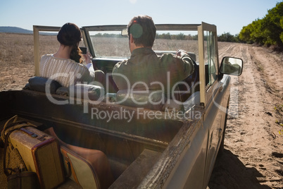Rear view of couple in off road vehicle on landscape