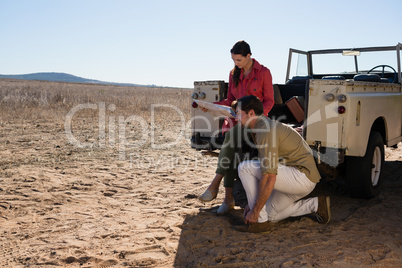 Woman with man holding map on landscape