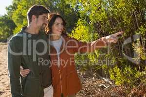 Woman with man pointing by trees