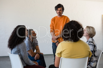 Man standing by fiends sitting on chair