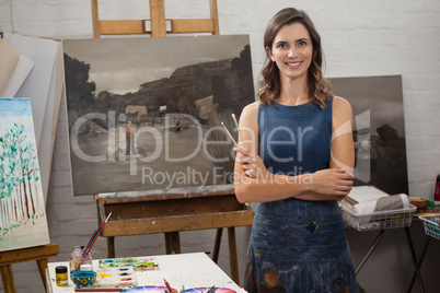 Portrait of happy woman standing with arms crossed