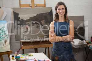 Portrait of happy woman standing with arms crossed