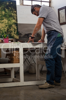 Attentive man painting at table