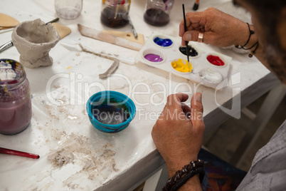 Man mixing watercolor in palette