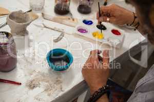 Man mixing watercolor in palette
