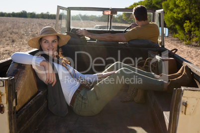 Woman relaxing with man driving off road vehicle