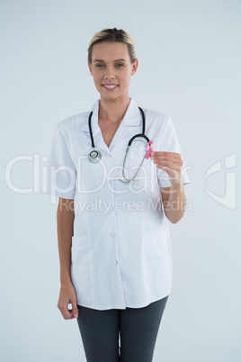 Portrait of confident female doctor showing Breast Cancer Awareness ribbon