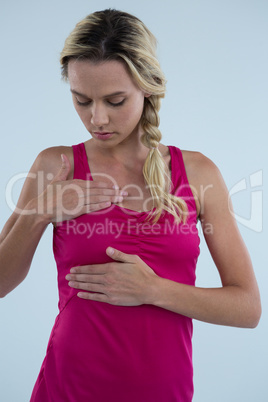 Woman examining breast for lumps