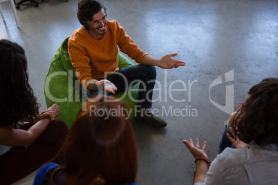 High angle view of friends talking while sitting on chair