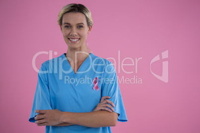Portrait of smiling female doctor in scrubs with arms crossed