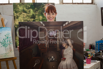 Portrait of beautiful woman holding her painting