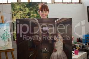 Portrait of beautiful woman holding her painting