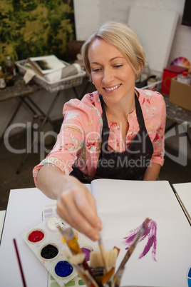Woman painting in drawing book