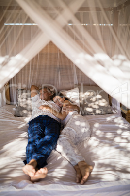 Couple relaxing in canopy bed