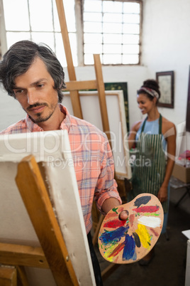 Man and woman painting on canvas