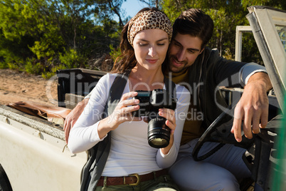 Young couple looking in camera at forest