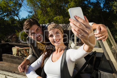 Couple taking selfie in off road vehicle