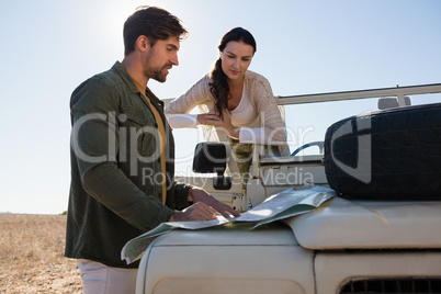 Couple reading map on off road vehicle