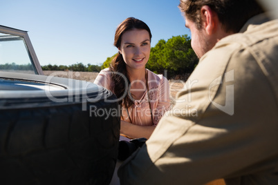 Woman by off road vehicle looking at man