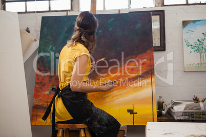 Woman painting on canvas