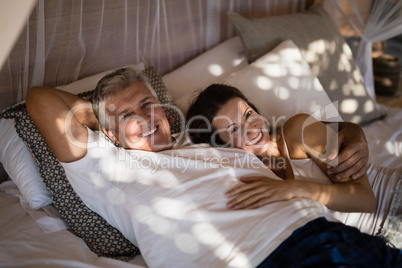 Happy couple relaxing in canopy bed