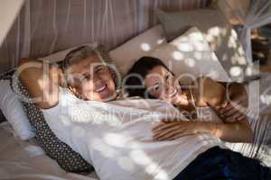 Happy couple relaxing in canopy bed