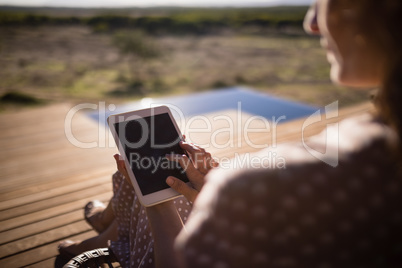 Senior woman using digital tablet while sitting