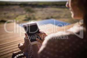 Senior woman using digital tablet while sitting