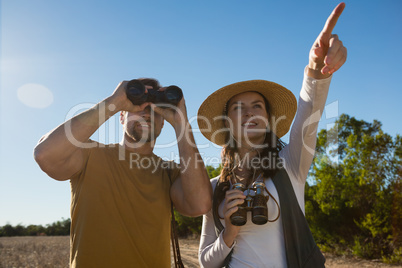 Young couple with binoculars at forest