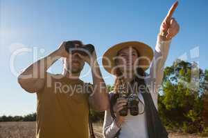 Young couple with binoculars at forest