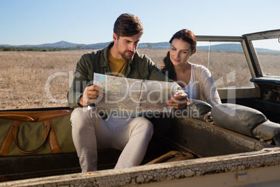 Couple reading map in off road vehicle