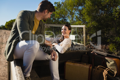 Smiling couple sitting in off road vehicle