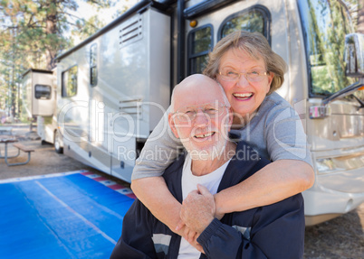 Senior Couple In Front of Their Beautiful RV At The Campground.