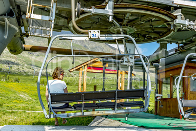 Woman in chair lift in Alp d Huez place in the french alps