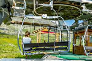 Woman in chair lift in Alp d Huez place in the french alps