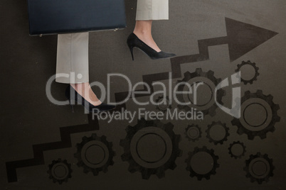 Composite image of low section of businesswoman climbing steps with briefcase