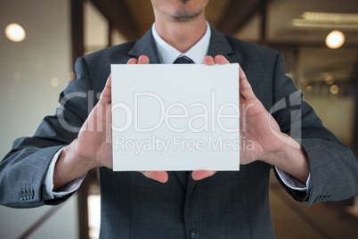 Business man holding blank card in office