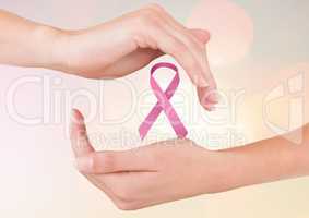 Open hands with pink ribbon for breast cancer awareness