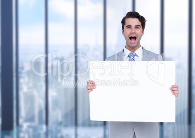 Excited business man holding blank card in office