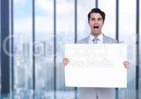 Excited business man holding blank card in office