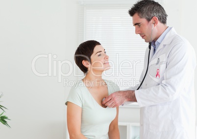 Doctor man with breast cancer awareness ribbon with patient