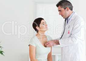 Doctor man with breast cancer awareness ribbon with patient