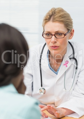 Doctor woman with breast cancer awareness ribbon and patient Doctor woman with breast cancer awareness ribbon and patient