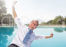 Businessman falling into swimming pool having fun