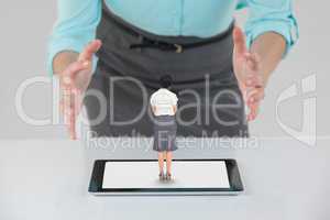 Big business woman with open hands and small business woman on a tablet