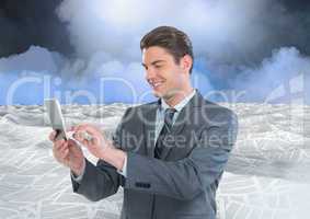 Businessman on phone in sea of documents under sky clouds