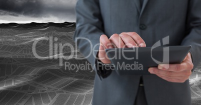 Businessman using tablet in sea of documents under sky clouds