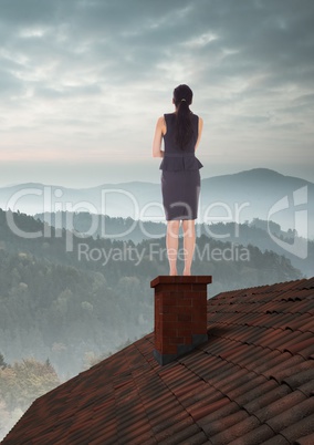 Businesswoman on roof with misty landscape