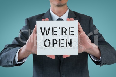 Business man holding a card with we are open text
